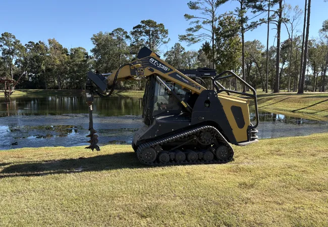 Skid steer auger drilling holes for land clearing and fencing in Polk County TX