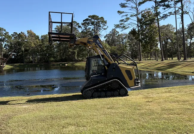 Skid steer man lift platform for safe tree trimming during land clearing in Livingston TX